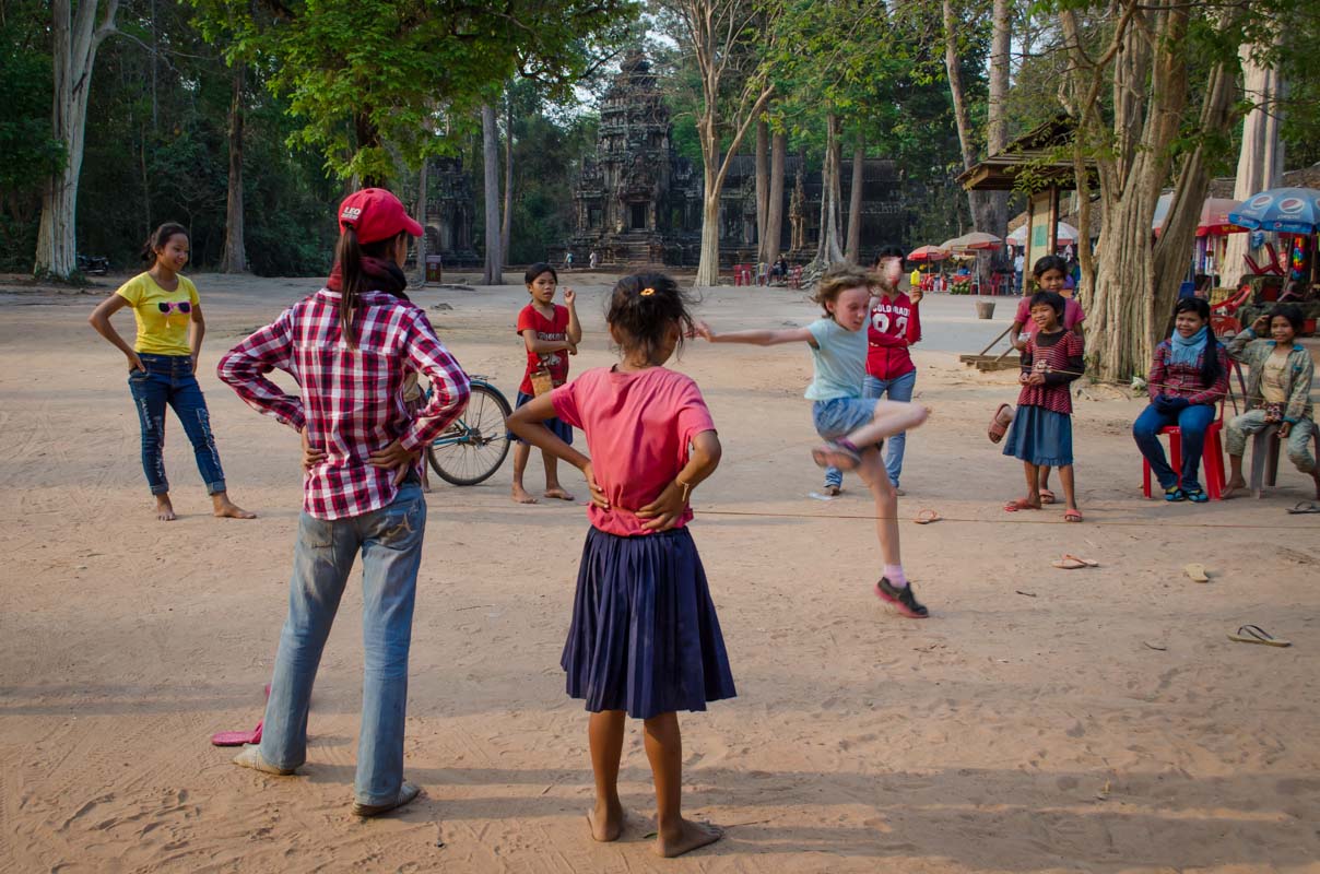 Children at Angkor Wat teaching Sydney how to play a local game